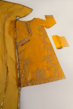 Adorned on pure raw silk 58 Gms, in a deep mustard yellow hue heavily embellished with gold zari, dabka, sequins and crystals. The length of the long kameez is 46 inches. Accompanied with gotah trousers and pure organza matching dupatta featuring gold gotah with Kiran lace. Order Duration: 4 to 6 weeks Luxury Yellow Dabka Salwar Kameez, Luxury Yellow Dabka Dupatta, Luxury Embellished Yellow Salwar Kameez, Luxury Gold Bollywood Churidar, Luxury Gold Churidar With Naqshi, Luxury Gold Churidar With Gold Embroidery, Luxury Gold Churidar With Self Design, Luxury Gold Churidar In Art Silk, Luxury Gold Unstitched Suit With Dori Work