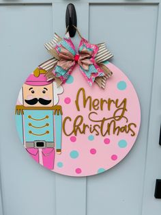 Nutcracker obsessed? We are too! We offer this door hanger in both traditional Christmas colors and a beautiful whimsical pink and turquoise. Most items are made to order, so please allow two weeks for us to create your item especially for you. Bow fabric may vary slightly from the photo. Wooden Cutout Door Hangers, Painted Round Door Hangers, Painted Door Hanger Ideas, New Year Door Hanger, Round Door Hanger Ideas, Nutcracker Door Hanger, Valentine Door Hanger Wooden, Round Wooden Door Hangers, Ladies Craft Night