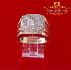 a gold ring with white diamonds on top and red background in the middle, sitting on a clear acrylic stand