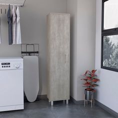 a white washer sitting next to a tall cabinet