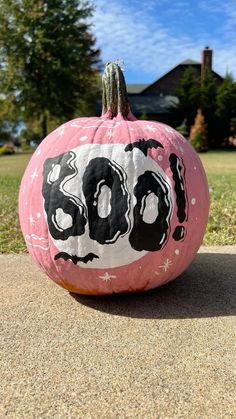 a painted pumpkin sitting on top of a sidewalk