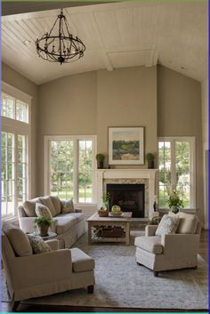 a living room with couches, chairs and a chandelier in it's center