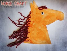 an orange paper horse with red hair on it's head and mane is shown