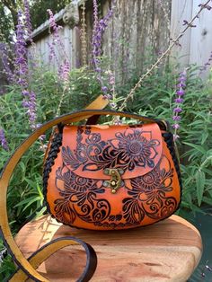 "Beautiful, embossed, genuine orange leather hand tooled floral crossbody purse, skillfully made by Artisans in Mexico using the \"cincelada\" technique. Latch closure and adjustable strap. Includes a storage bag to protect your purse when not in use. Dimensions: 8\" L x 4\" W x 6\" H. (small sized purse). It will fit the standard size phones, and a small wallet, keys and chapstick and or travel sized products, but not an oversized phone (max, plus, etc). Please check measurements if you have any concerns about sizing before purchasing. Imported from Mexico, they are a continuation of the fine craftsmanship established in that country going back hundreds of years with carved leather saddles. These beauties are not like the more common stamped products that can be mass produced cheaply and Mexican Made Purse, Bohemian Hand Tooled Leather Shoulder Bag, Bohemian Hand Tooled Saddle Shoulder Bag, Leather Mexican Purse, Luxury Hand Tooled Crossbody Bag, Bohemian Hand Tooled Crossbody Bags, Cottage Fashion, Mexican Purse, Mexican Bag