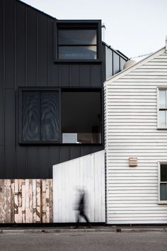 a blurry image of a person riding a bike past a building with wooden slats