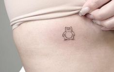 a woman's stomach with a small tattoo of a cat on the side of her belly