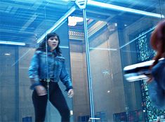 a woman standing in front of a glass wall