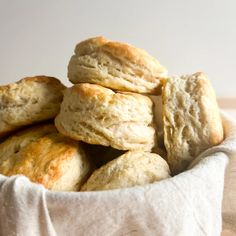 a white basket filled with biscuits on top of a wooden table