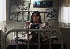 a woman sitting on top of a metal bed