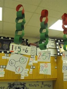 some paper chains hanging from the ceiling in an office cubicle with writing on them