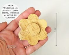 a person holding a wooden object in their hand with measurements for the flower on it