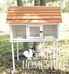 a white chicken coop under a tree with the words hello momma written on it in front of it