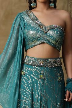 Teal blue textured lehenga with placement embroidery. Paired with a blouse with matching texture and embroidery on neckline and a ruffled net dupatta. - Aza Fashions Sequins Lehenga, Cape Lehenga, Asymmetric Blouse, Lehenga And Blouse, Kurta Lehenga, Placement Embroidery, Lehenga Pattern, Blue Lehenga, Blouse Cotton