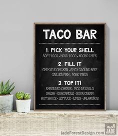 a sign that says taco bar on the side of a shelf next to potted plants