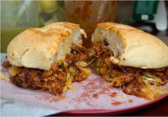 a pulled pork sandwich cut in half on a plate