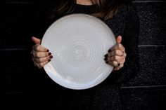 a woman holding a white plate in her hands