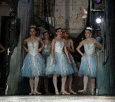 four ballerinas in blue tulle dresses standing next to each other with their hands on their hips