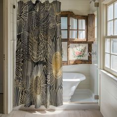 a bathroom with a shower curtain that has an image of leaves on it in gold and black