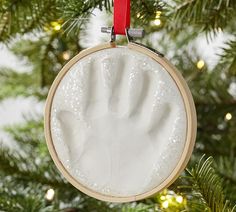 a handprint ornament hanging from a christmas tree