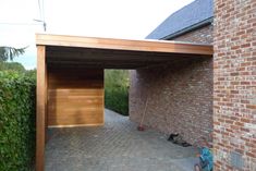 a brick building with a wooden roof and an open door on the side of it