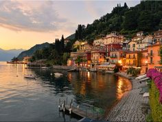 an image of a town by the water at sunset or dawn with boats in the water