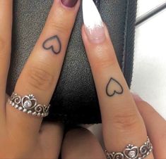 two fingers with hearts on them, one has a ring and the other has a heart