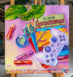 a painting of a game controller and other items on a easel with a green plant in the background