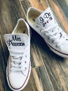 two white shoes with the words mr and mrs on them sitting on a wooden floor