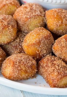 some sugar covered donuts on a white plate