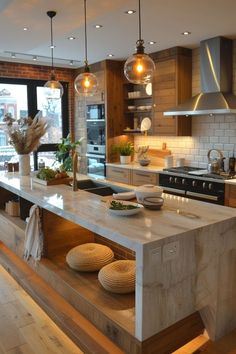 a large kitchen with an island in the middle and lots of lights hanging from the ceiling