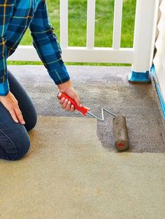 a woman kneeling down on the ground with a tool