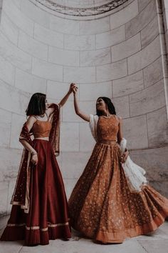 two women standing next to each other holding hands