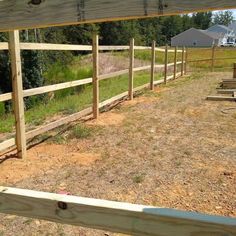 a wooden fence in the middle of a field