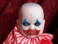 a close up of a person wearing clown makeup on a red and white striped background