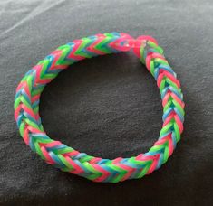 a multicolored rope bracelet sitting on top of a black surface