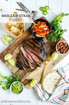 sliced steak on a cutting board with chips, salsa and lime wedges next to it