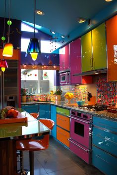 a colorful kitchen with lots of counter space and lights hanging from the ceiling over the stove