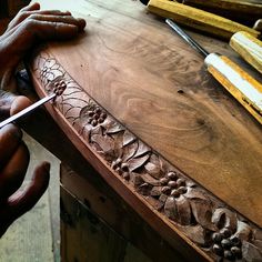 a person is carving something on a wooden table