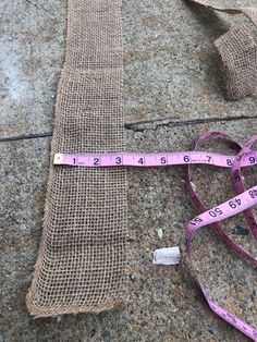 a pair of measuring tape is laying on the ground next to a burlap bag