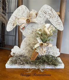 an angel statue with flowers in it sitting on a table