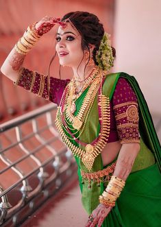 a woman dressed in green and gold is posing for the camera with her hands on her head