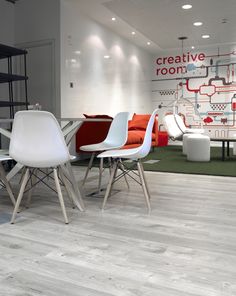 an office with white chairs and tables in the middle of it's flooring