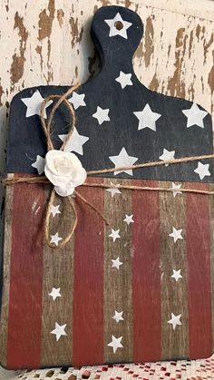 a wooden cutting board with an american flag design on it, tied to a piece of wood