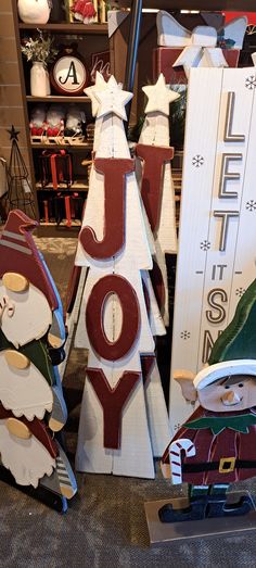 christmas decorations are displayed in front of a store sign that says joy and santa claus