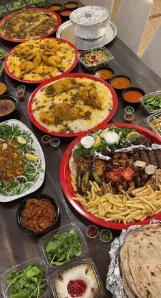 a table topped with lots of different types of food and plates filled with meats