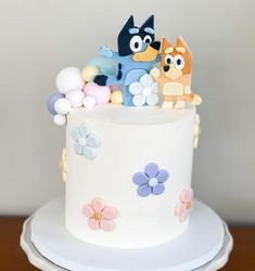 the cake is decorated with cartoon characters on it's top and bottom tiers