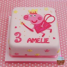 a pink birthday cake with peppa the pig on it's face and name