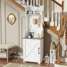 a living room with stairs and a white cabinet in the corner next to a stair case