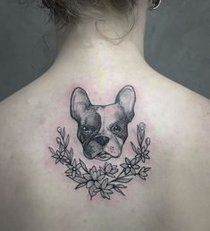 the back of a woman's neck with a small tattoo of a dog