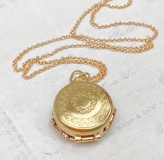 A romantic long pendant locket necklace. This golden brass round locket folds out to reveal space for four different photos. A spring-loaded locket pops open to reveal 2 hinged panels, just 1 inch in diameter. It opens to hold 4 photographs. The locket is suspended from a gold plated brass rolo chain with soldered links. The chain is non tarnishing and closes with a lobster claw clasp. Locket measures approx.  - 1 inch in diameter (25mm) The inside of the locket has space for - 2 small round photos - 18mm in diameter 2 larger round photos - 20mm in diameter You can personalize the locket by printing your own photos and inserting them inside the locket. (Photo insertion not included.)  Print your own photos, cut and add a spot of glue to keep the photos in place. Please note -  This locket Golden Locket Aesthetic, Locket Necklace Aesthetic, Golden Locket, Medieval Things, Locket Vintage, Locket Necklaces, Pendant Locket